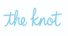 - The official logo for "the knot." The brand name is written in a light blue, handwritten-style cursive font on a solid white background. The text is lowercase and features a whimsical, elegant design.